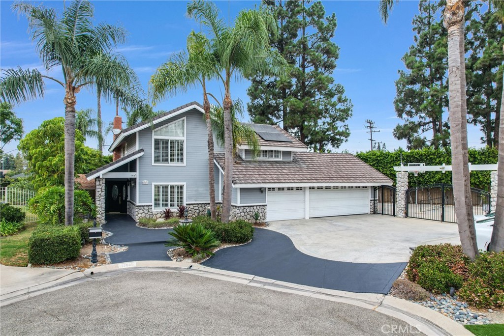 a front view of a house with a garden and mountain