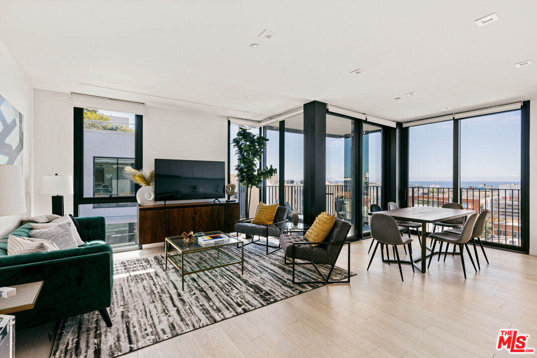 a living room with furniture a fireplace and large windows