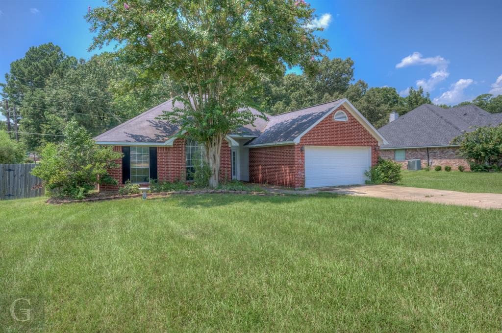 a front view of a house with a yard and trees