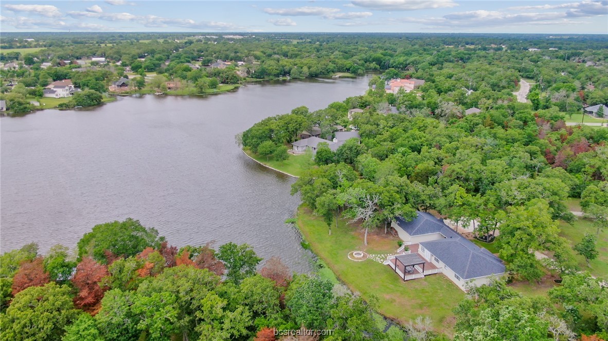 an aerial view of a house with a garden and lake view