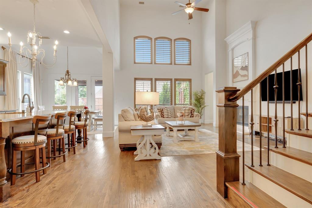 a living room with lots of furniture wooden floor and a large window