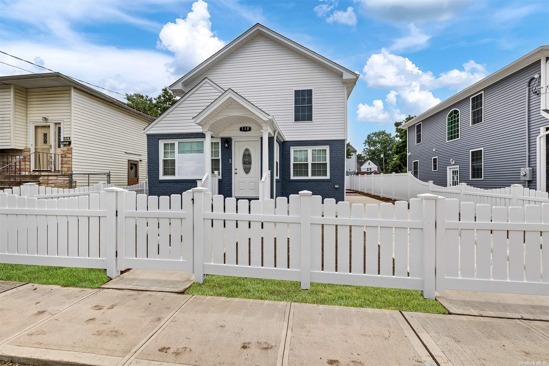 a view of a house with wooden fence next to a yard