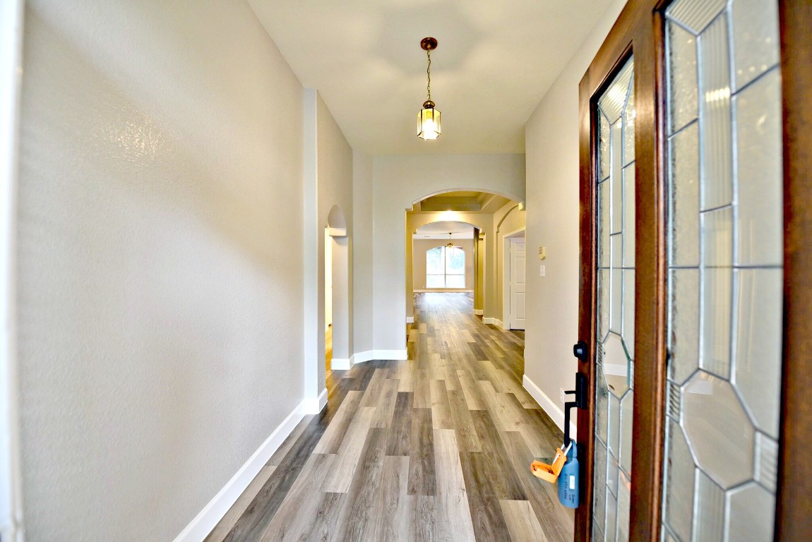 a view of a hallway with wooden floor and staircase