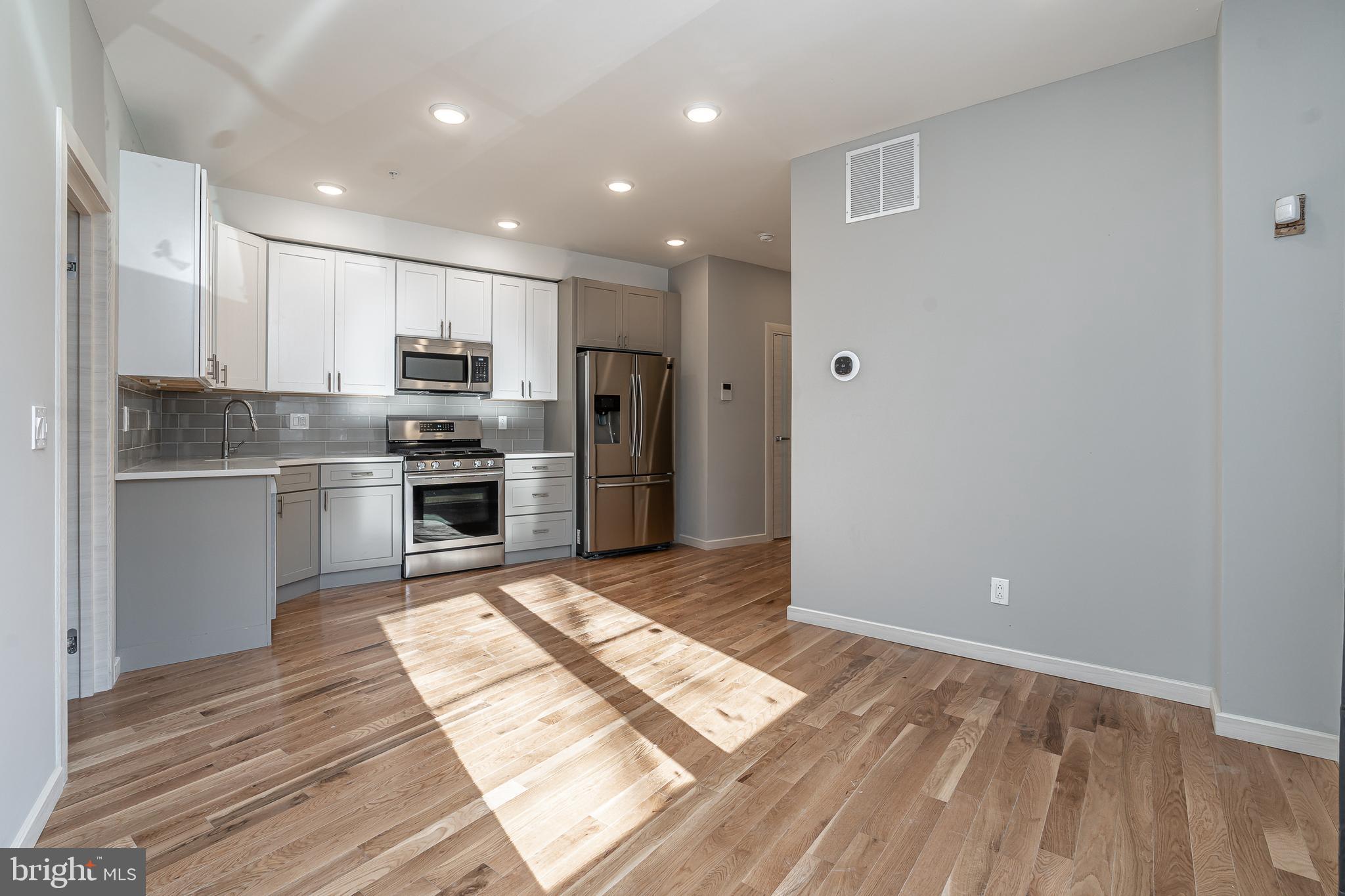 a kitchen with stainless steel appliances granite countertop a refrigerator and a stove top oven