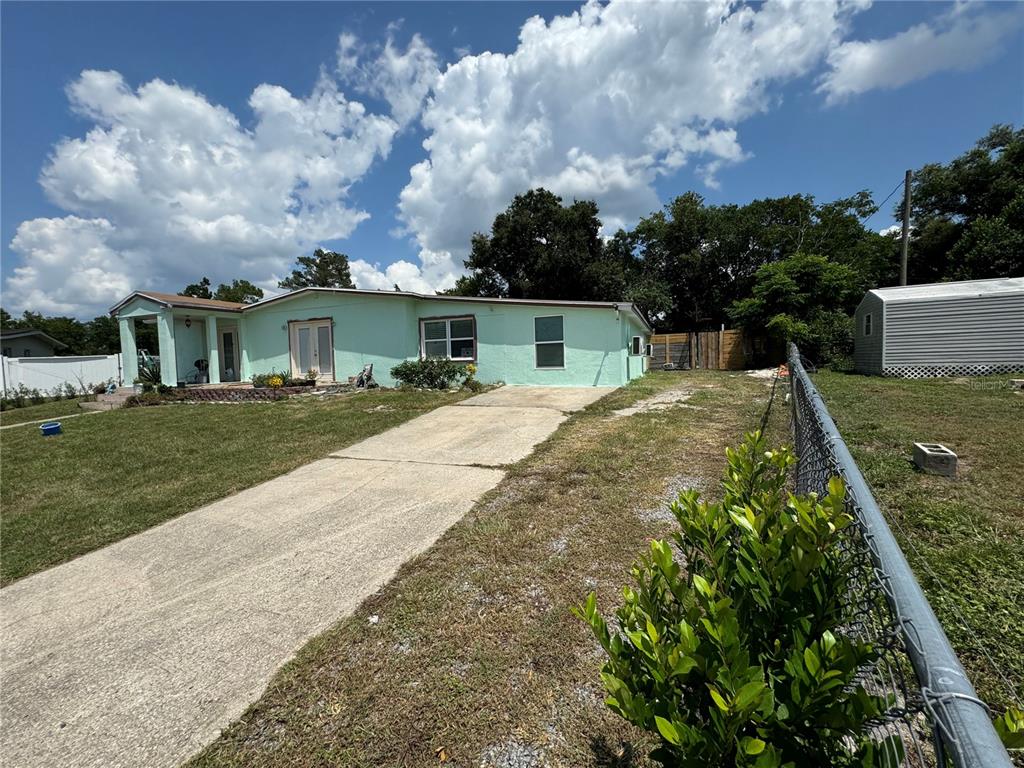 a view of house with yard and trees in the background