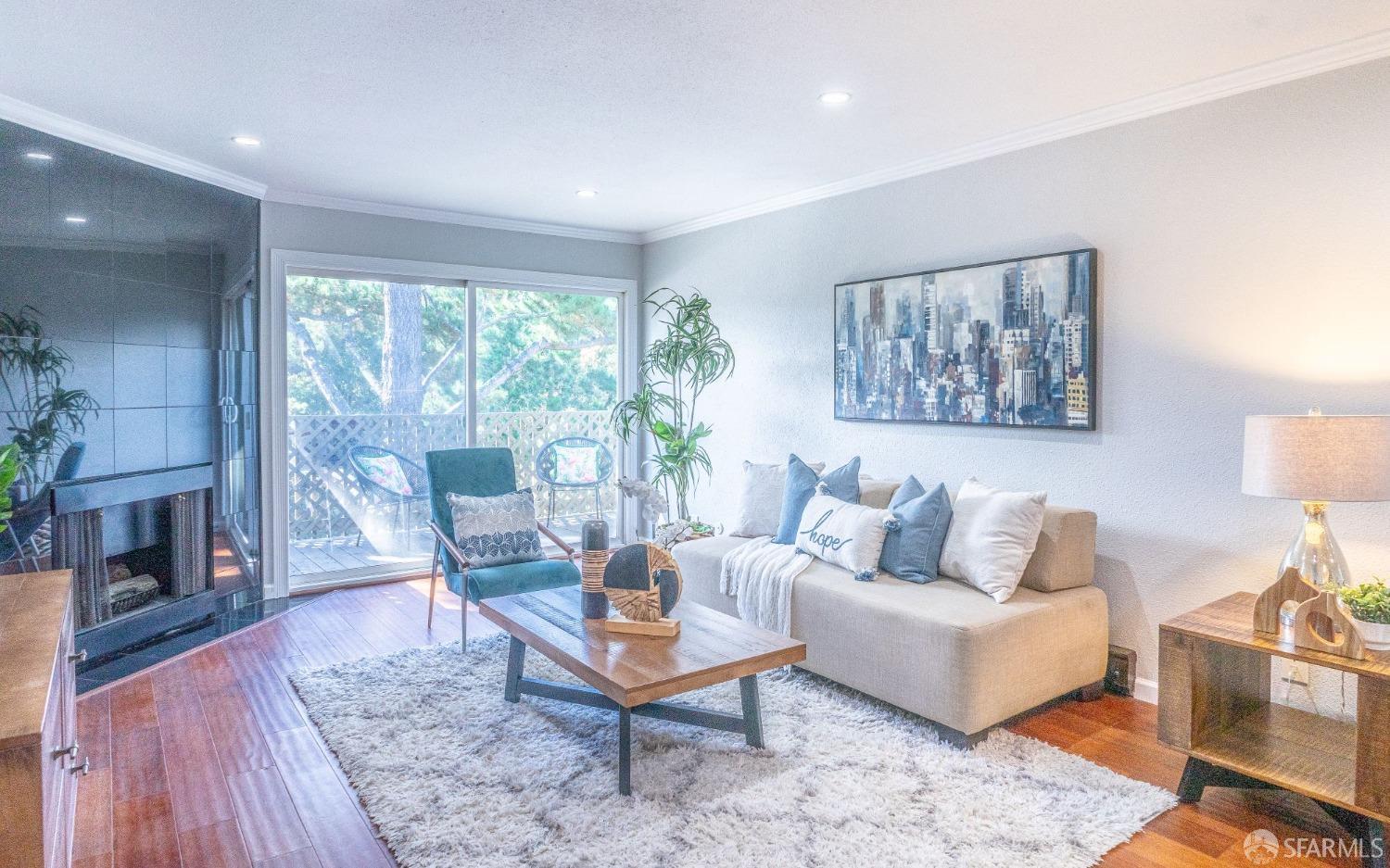 a living room with furniture a large window and a fireplace