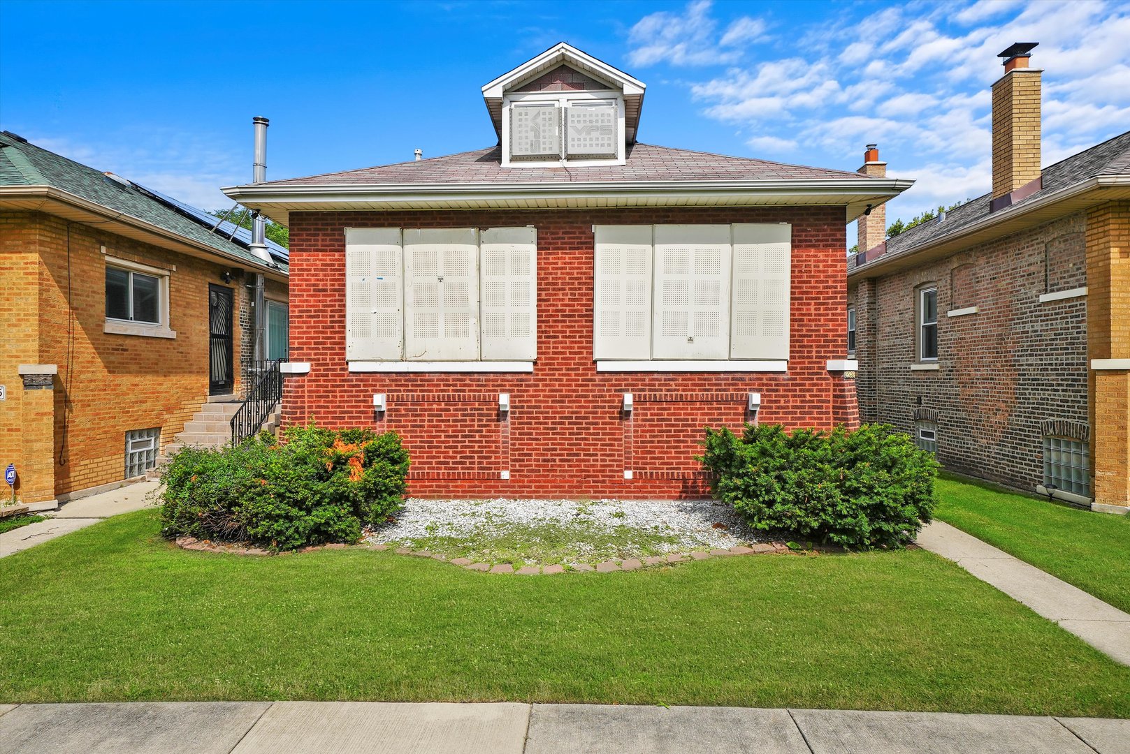 a front view of a house with a garden