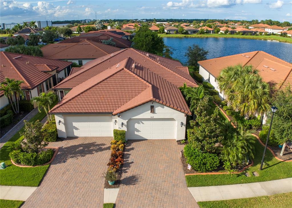 an aerial view of house with yard space and lake view