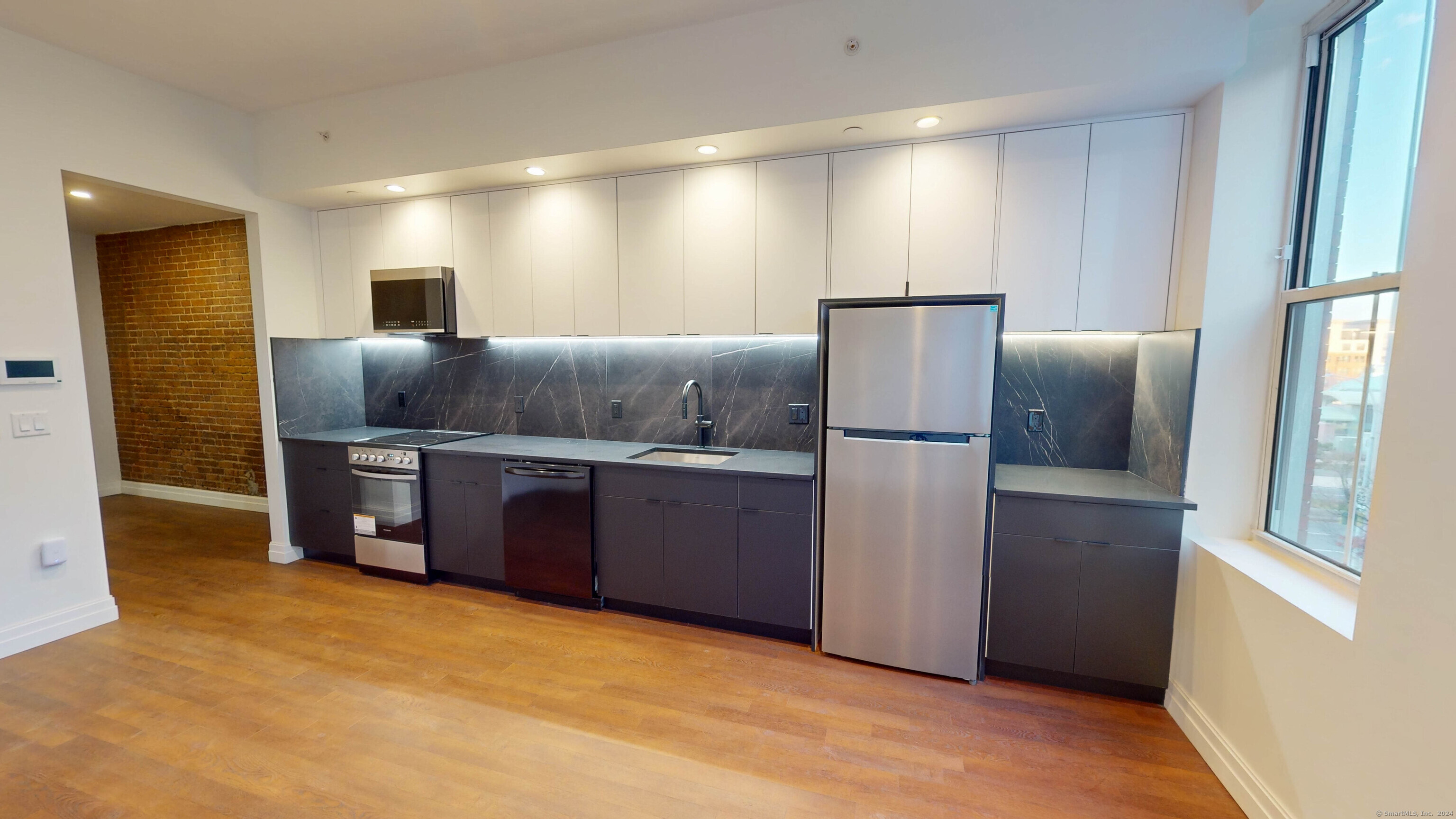 a kitchen with stainless steel appliances granite countertop a refrigerator and a stove