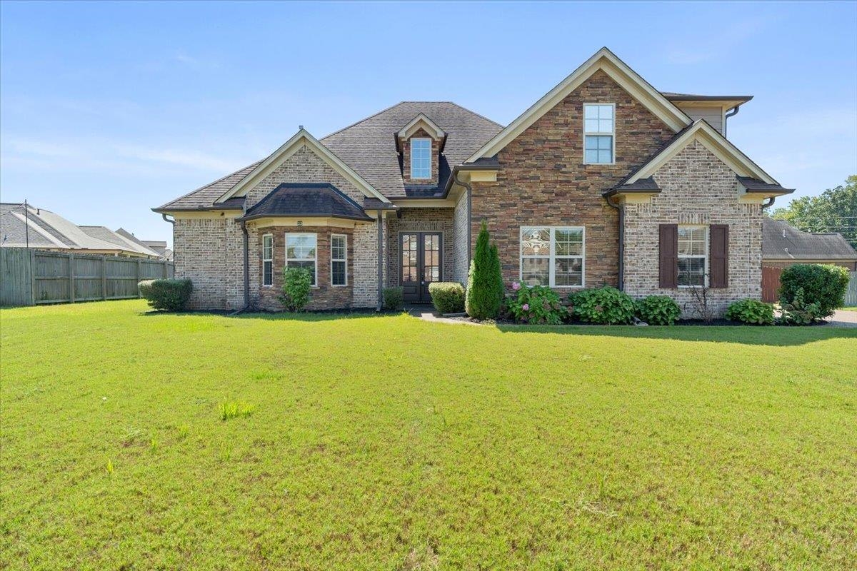 a front view of a house with yard and green space