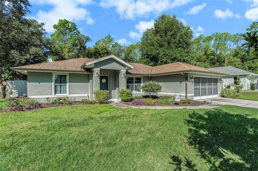 a front view of a house with yard patio and green space