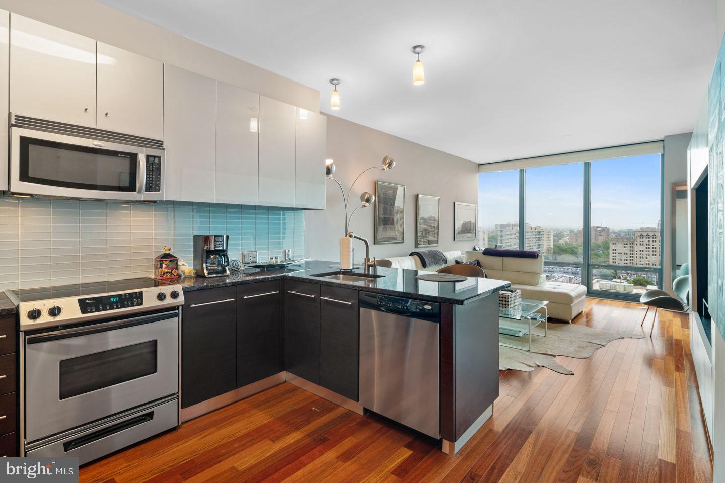 a kitchen with stainless steel appliances granite countertop a stove and a wooden floors