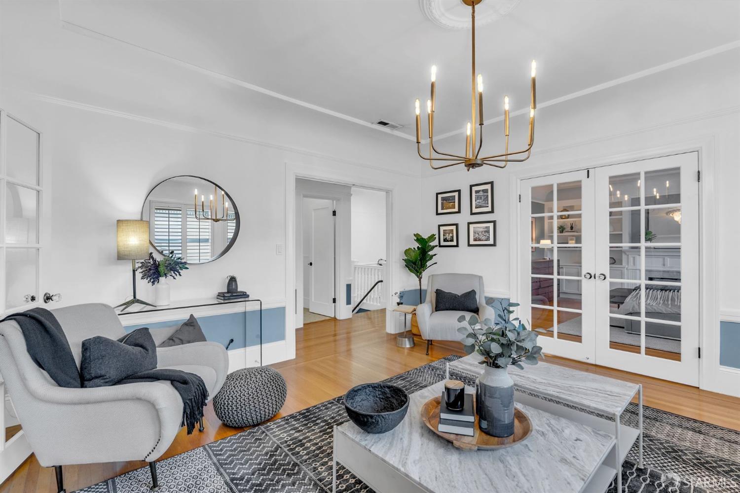 a living room with furniture chandelier and a view of kitchen