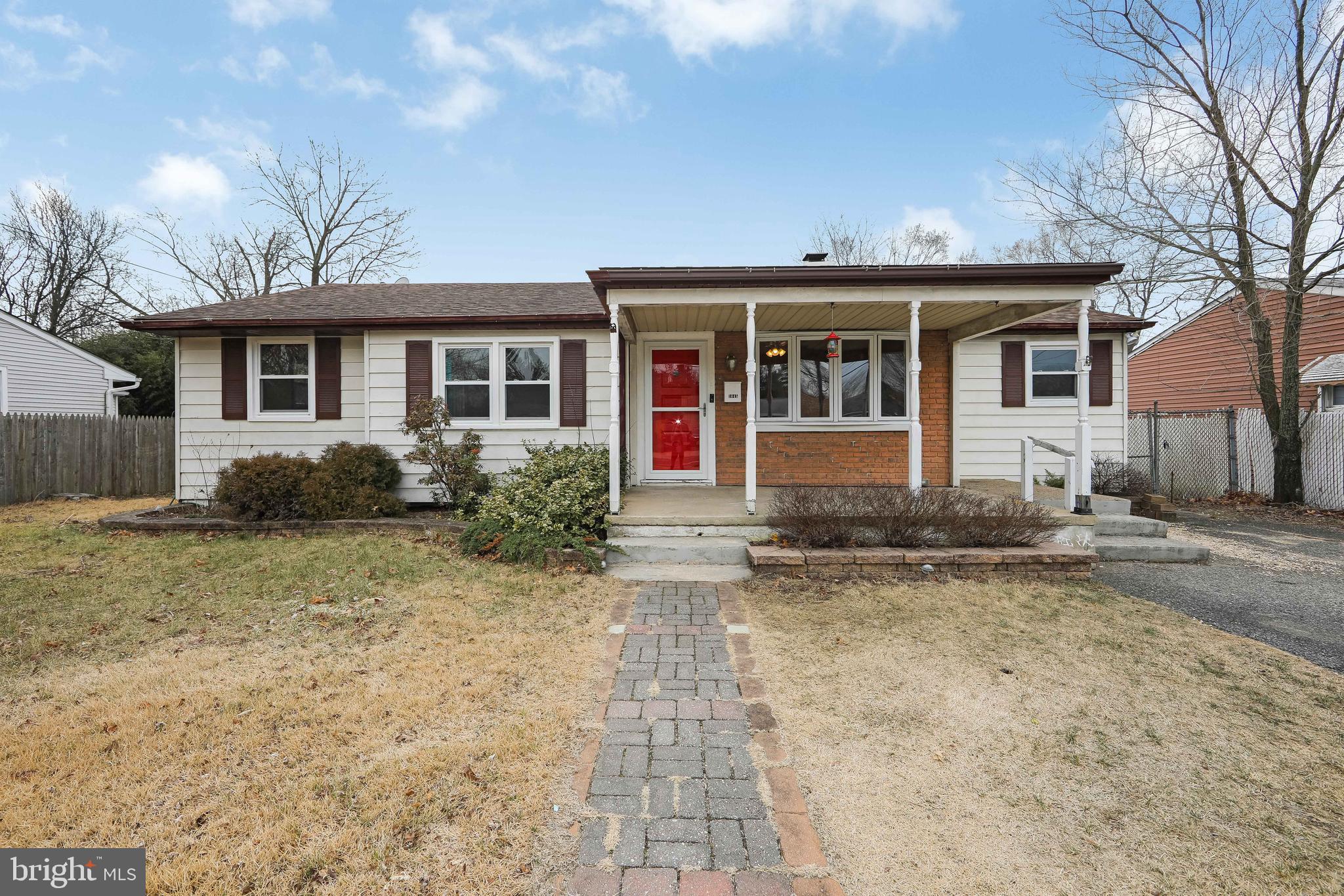 a front view of a house with a yard and potted plants