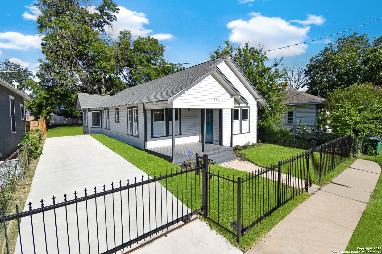 a view of a house with wooden fence next to a yard