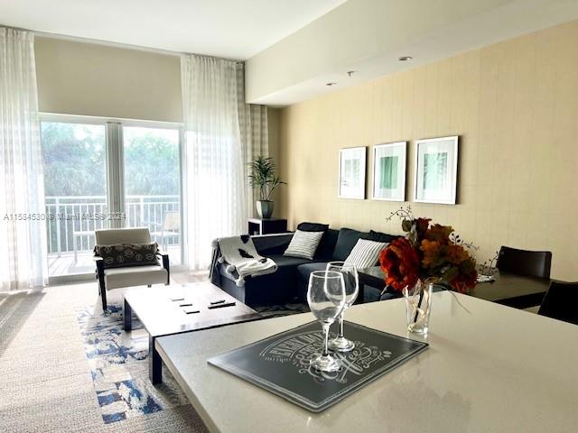 a living room with furniture a rug and a large window