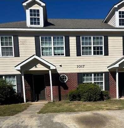 front view of a brick house with a yard