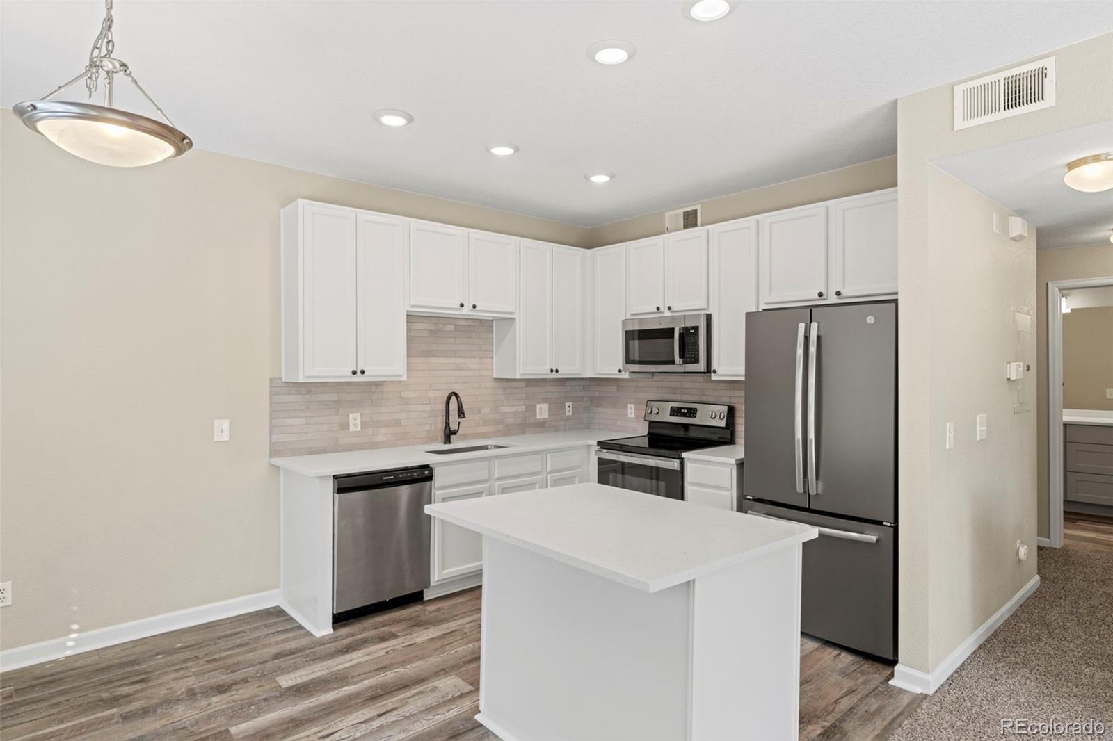 a kitchen with refrigerator cabinets and wooden floor