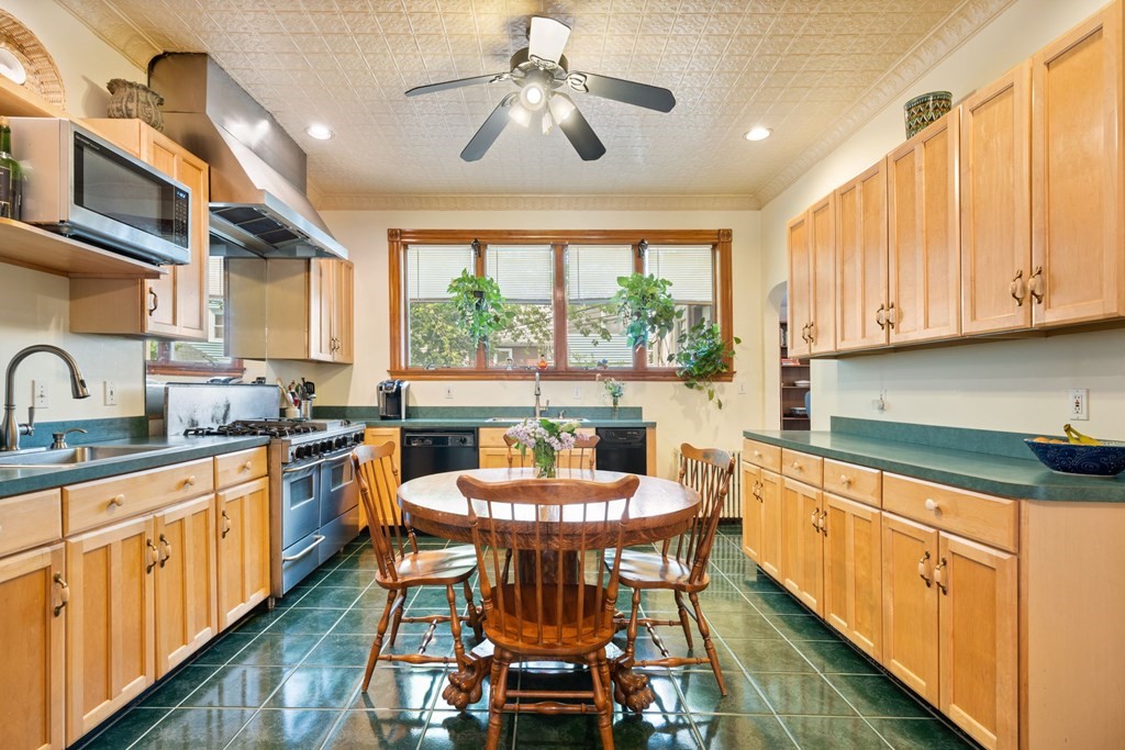 a kitchen with stainless steel appliances granite countertop a stove a sink dishwasher and cabinets with wooden floor