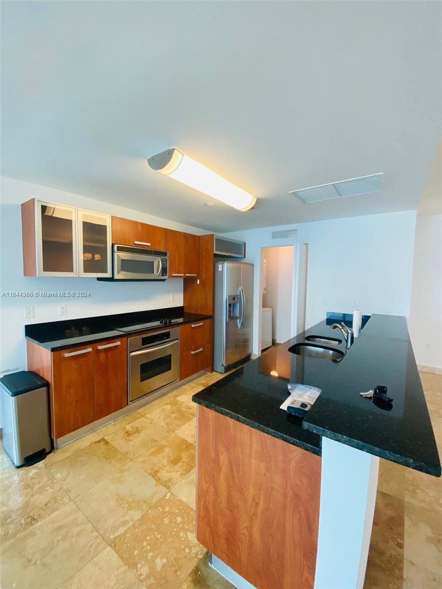 a kitchen with stainless steel appliances a stove a sink and a refrigerator