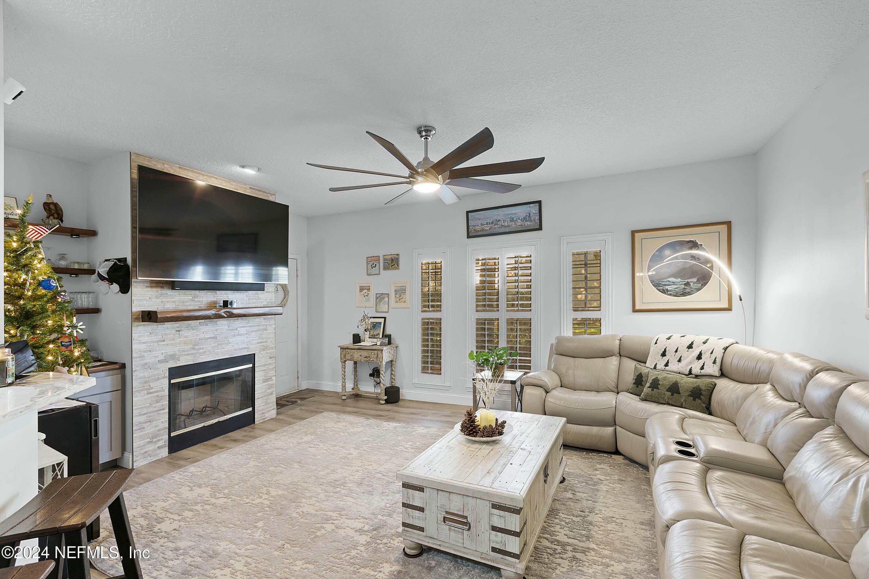 a living room with furniture a flat screen tv and a fireplace