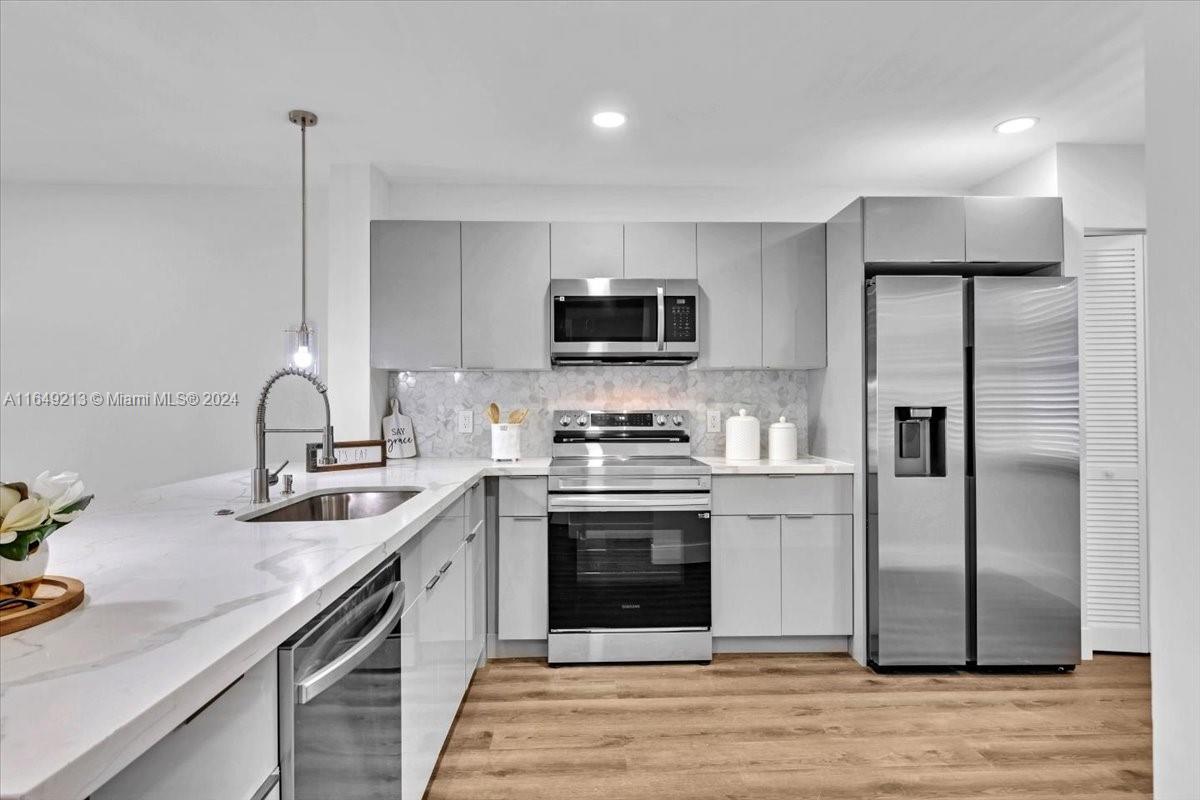 a kitchen with stainless steel appliances granite countertop a sink stove and refrigerator