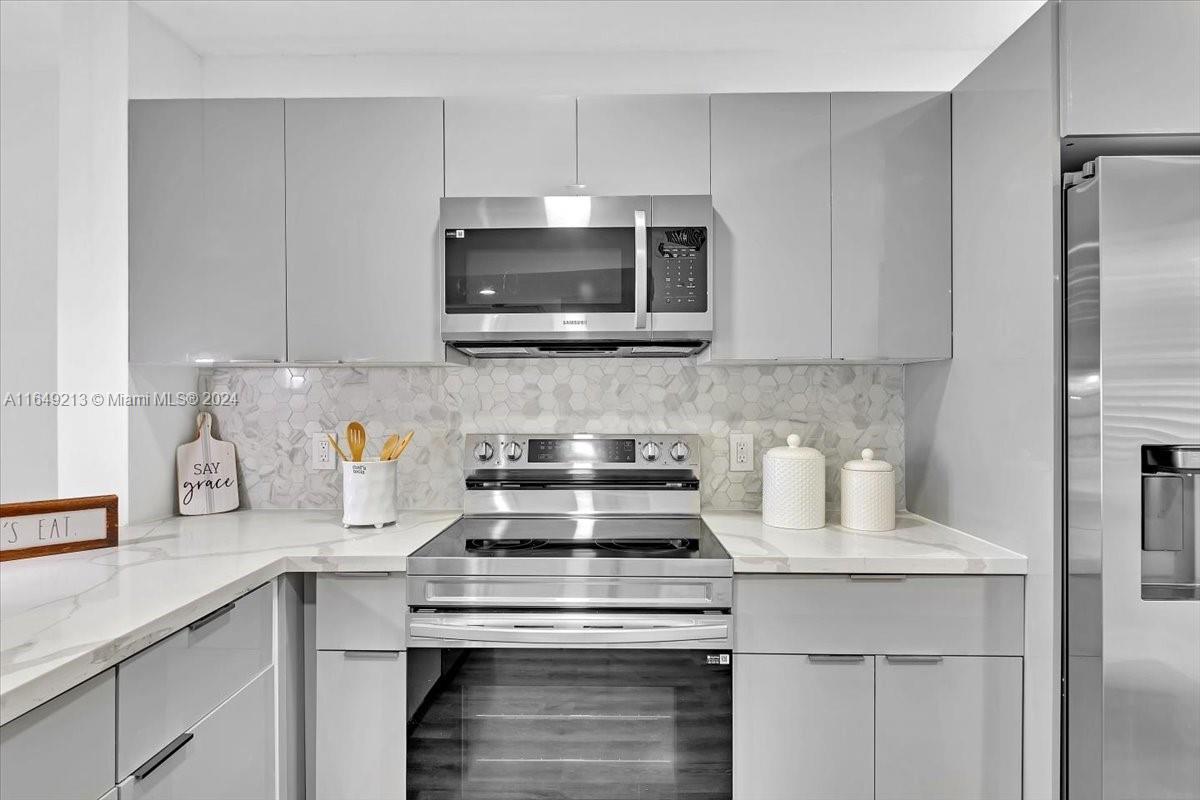 a kitchen with appliances a sink and cabinets