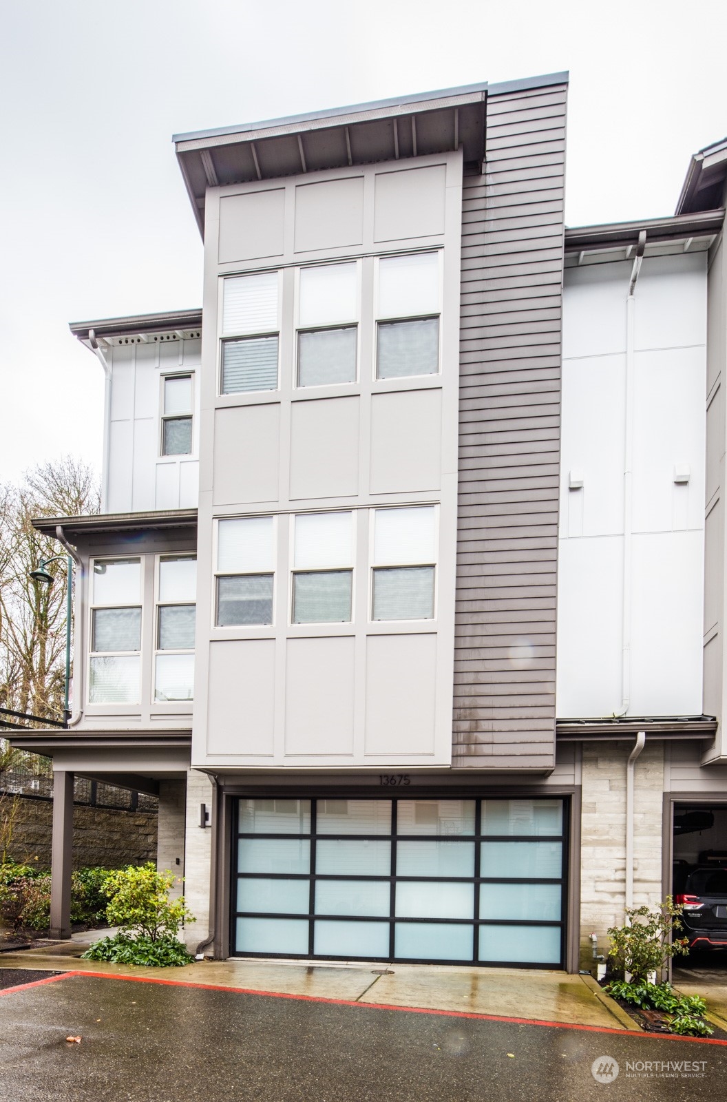 a front view of a house with a yard and parking