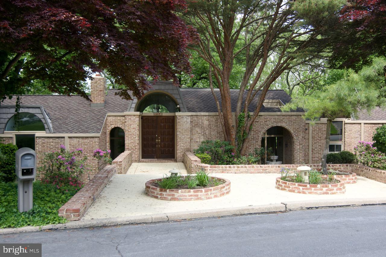 a view of white house with a yard and large tree