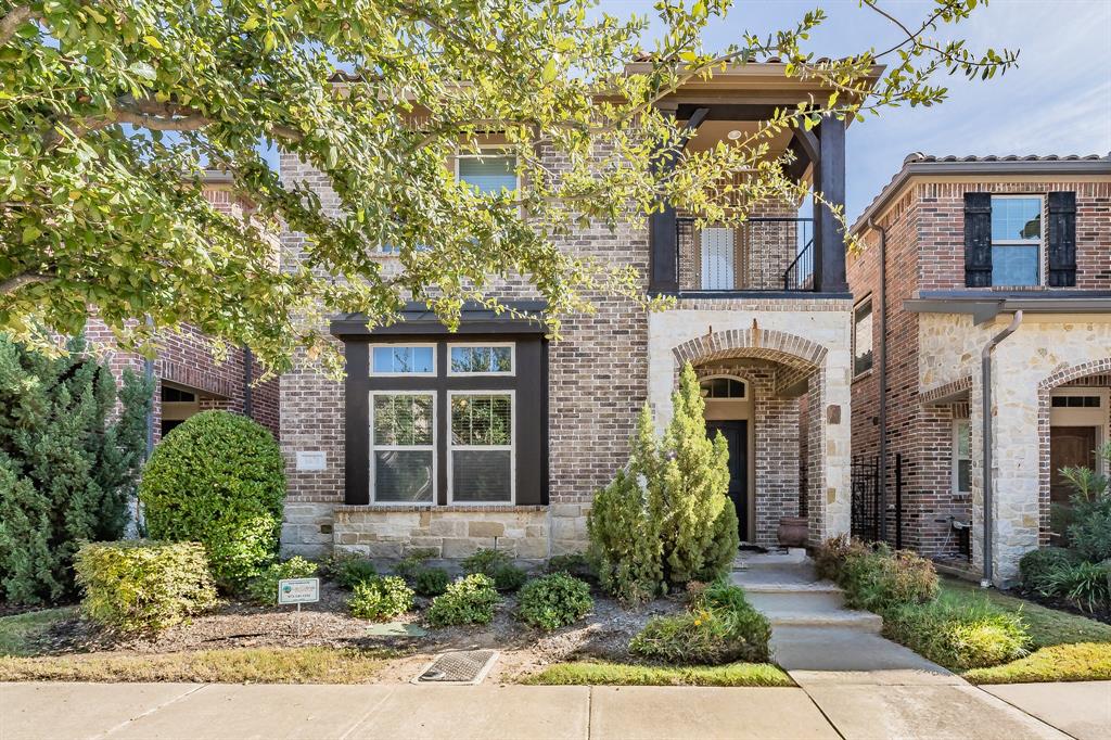 front view of a brick house with a yard