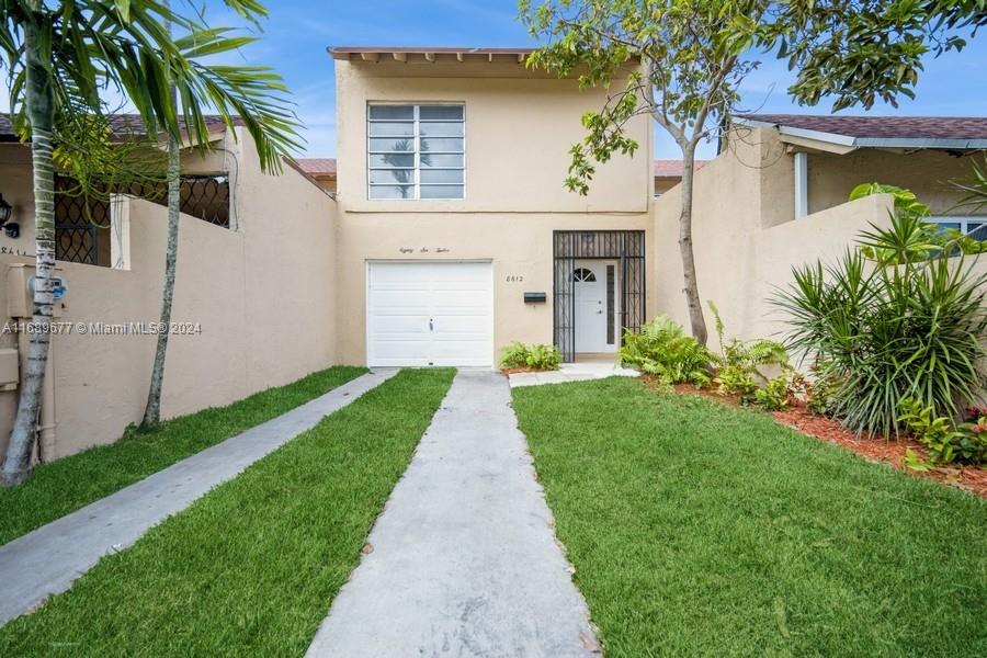 Front entrance has its own privacy walls, a 1C-garage and that is an Avocado Tree on the right. You can park 2 cars deep in the driveway. The windows on the second floor are the Primary Bedroom's windows facing East.