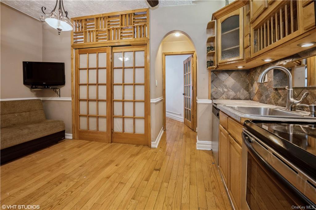 a view of a livingroom with wooden floor and a kitchen