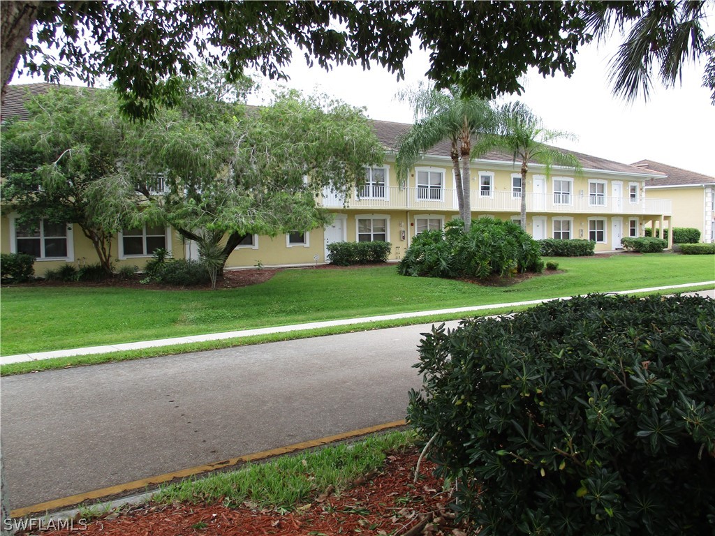 a view of a house with a big yard and large trees