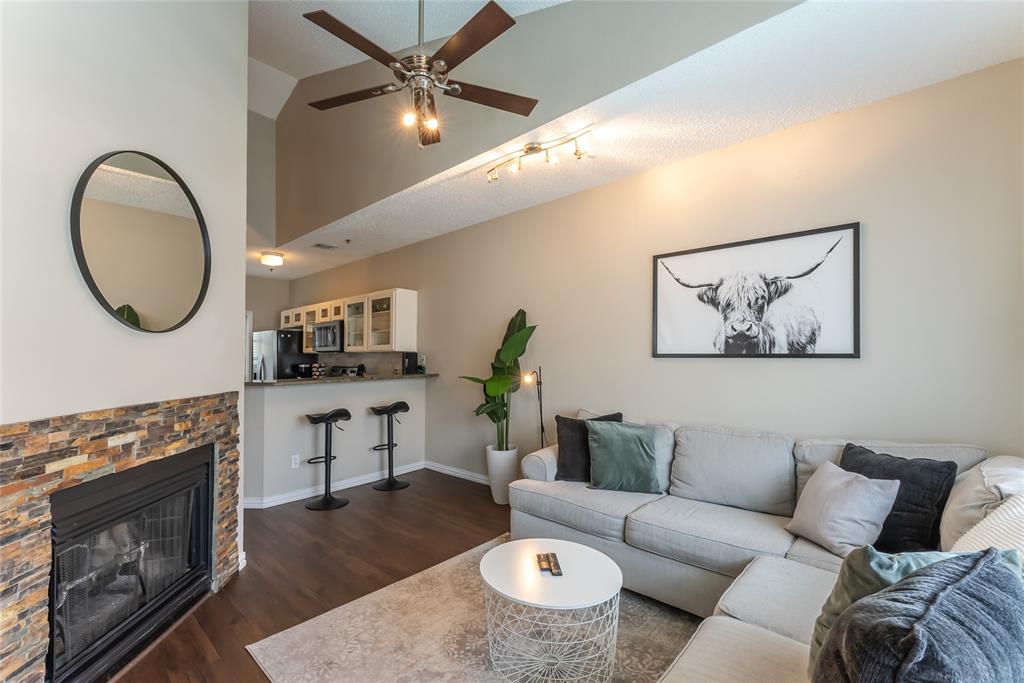 a living room with furniture a fireplace and wooden floor