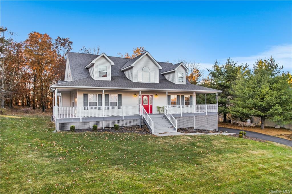 Farmhouse-style home with a front yard and covered porch