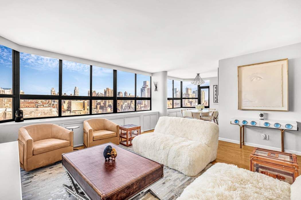 a living room with furniture and a floor to ceiling window