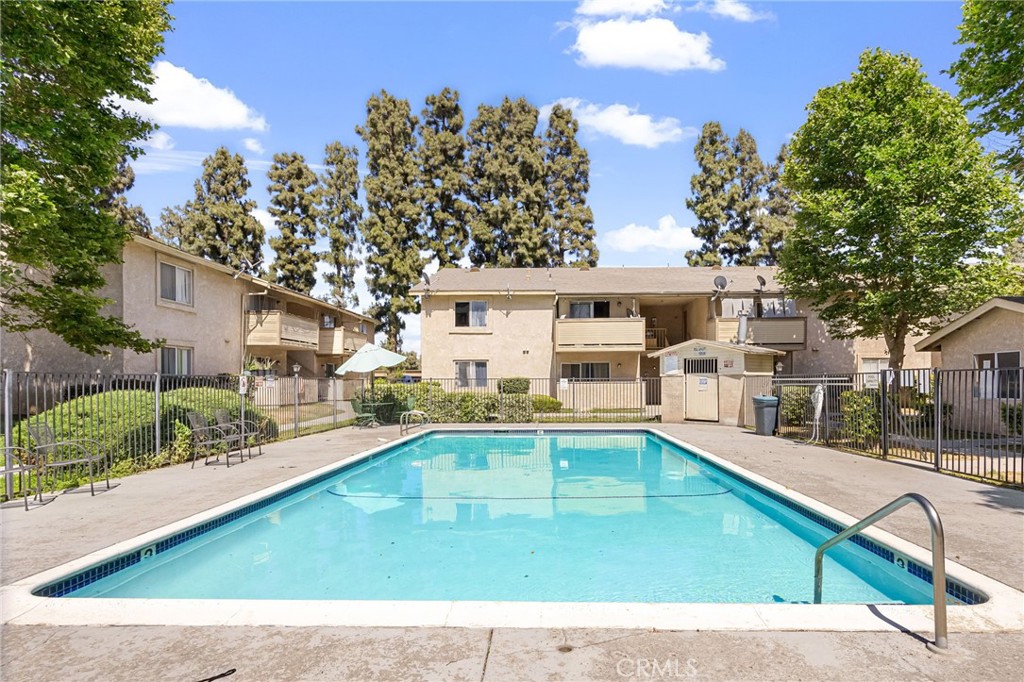 a view of swimming pool with outdoor seating and house in the background