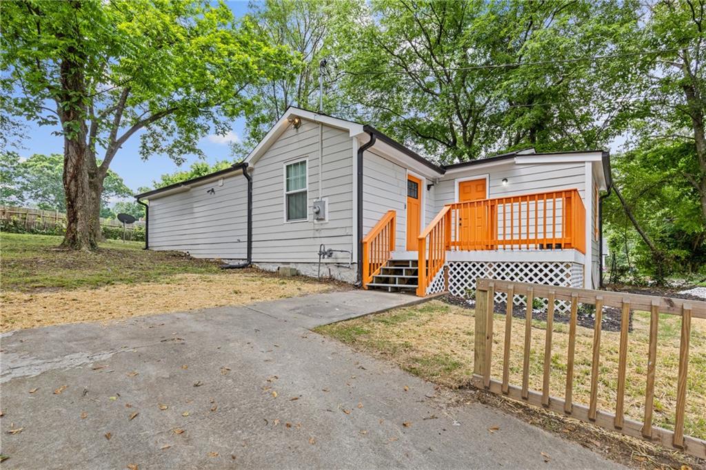 a view of a house with a small yard and wooden fence