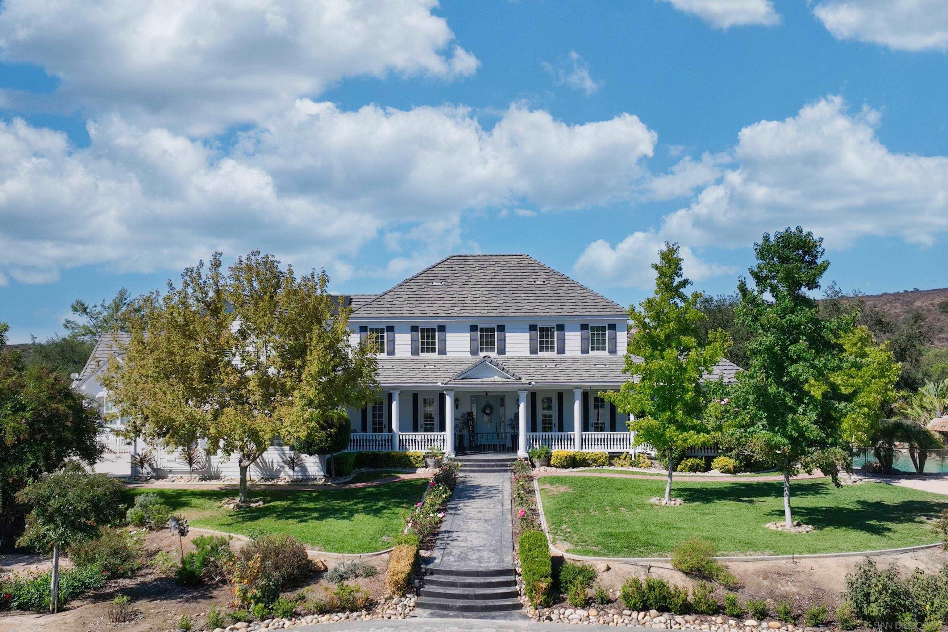 a front view of a house with a garden and plants