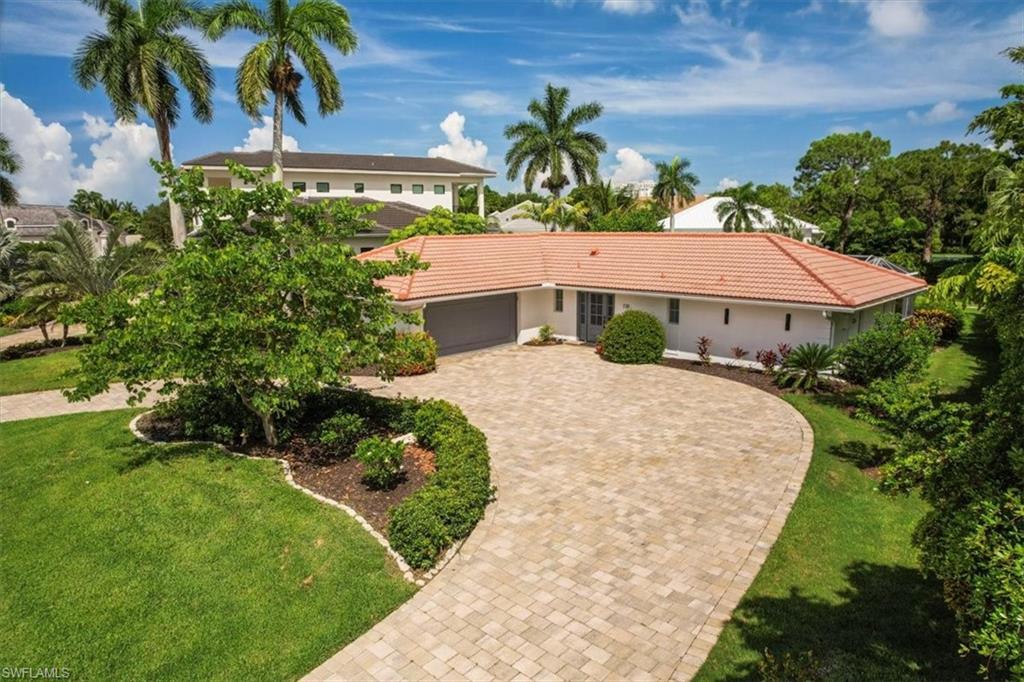 View of front facade with a 2 car garage, circular drive and a front lawn