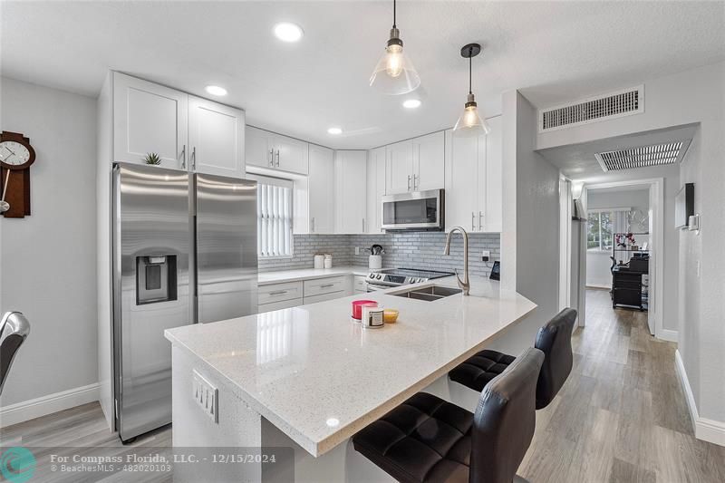 a kitchen with kitchen island a sink appliances and cabinets