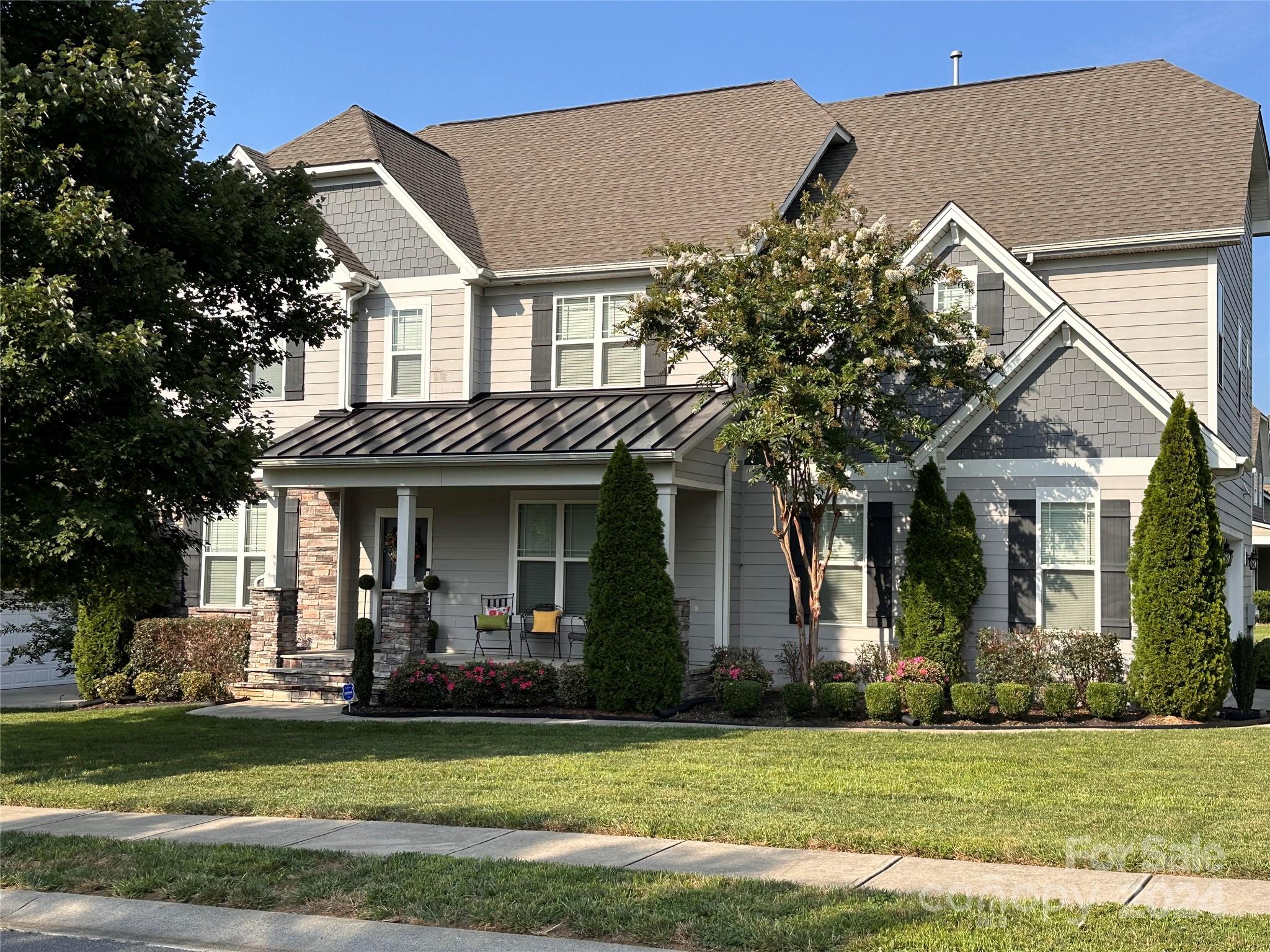 a front view of a house with a garden and plants