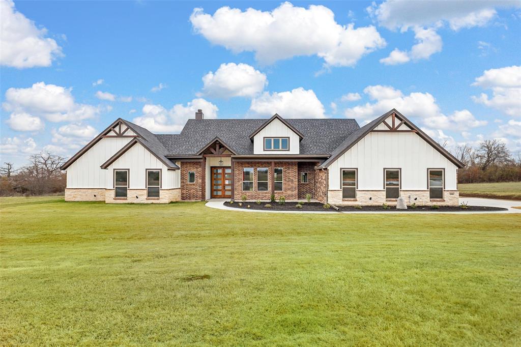 a view of a house with a big yard and large trees