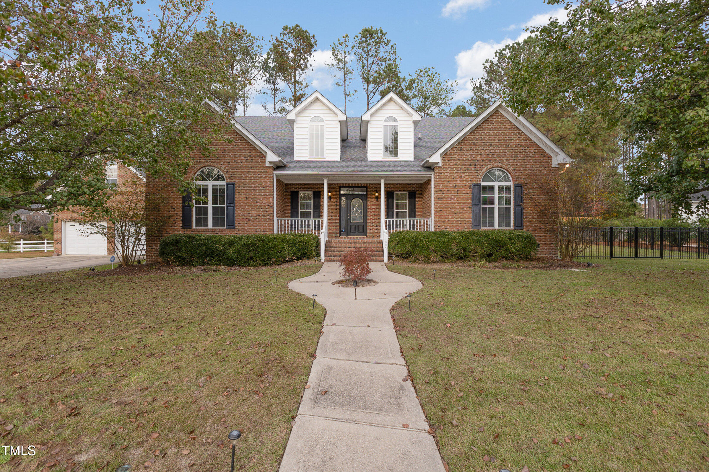 a front view of a house with a yard and trees