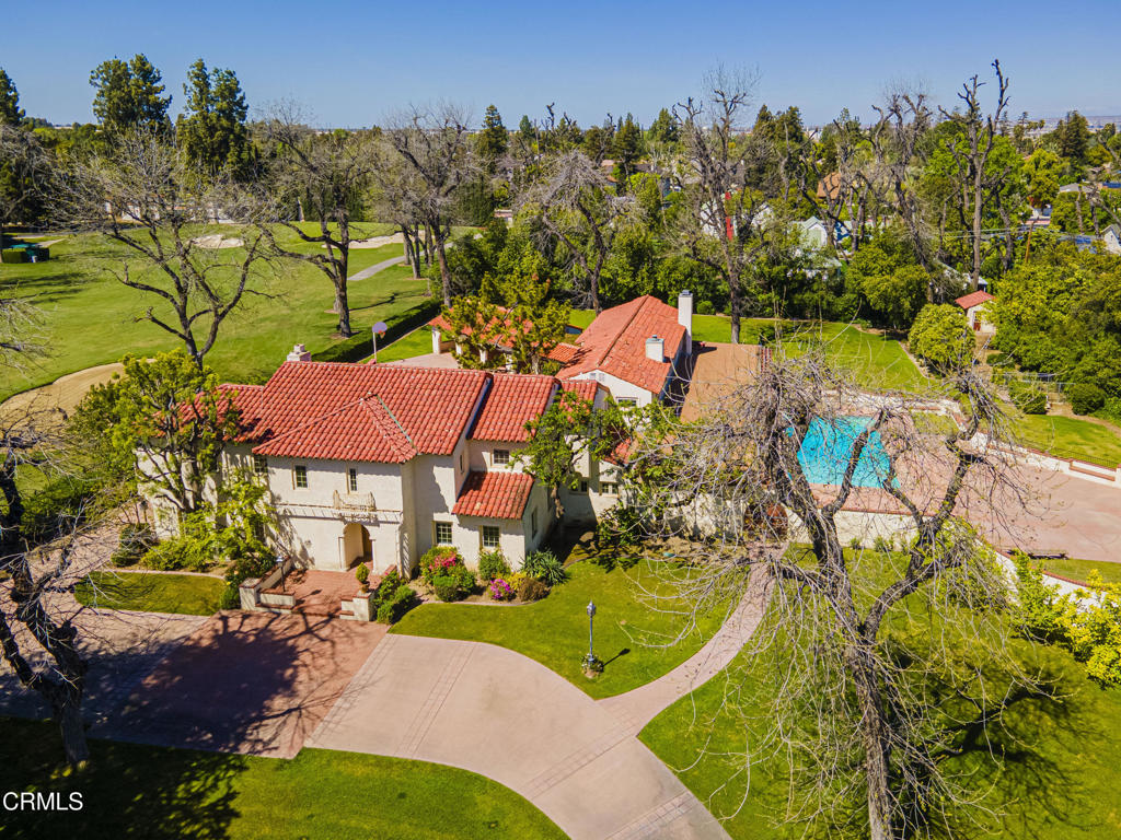 an aerial view of a house with a swimming pool a patio and mountain view