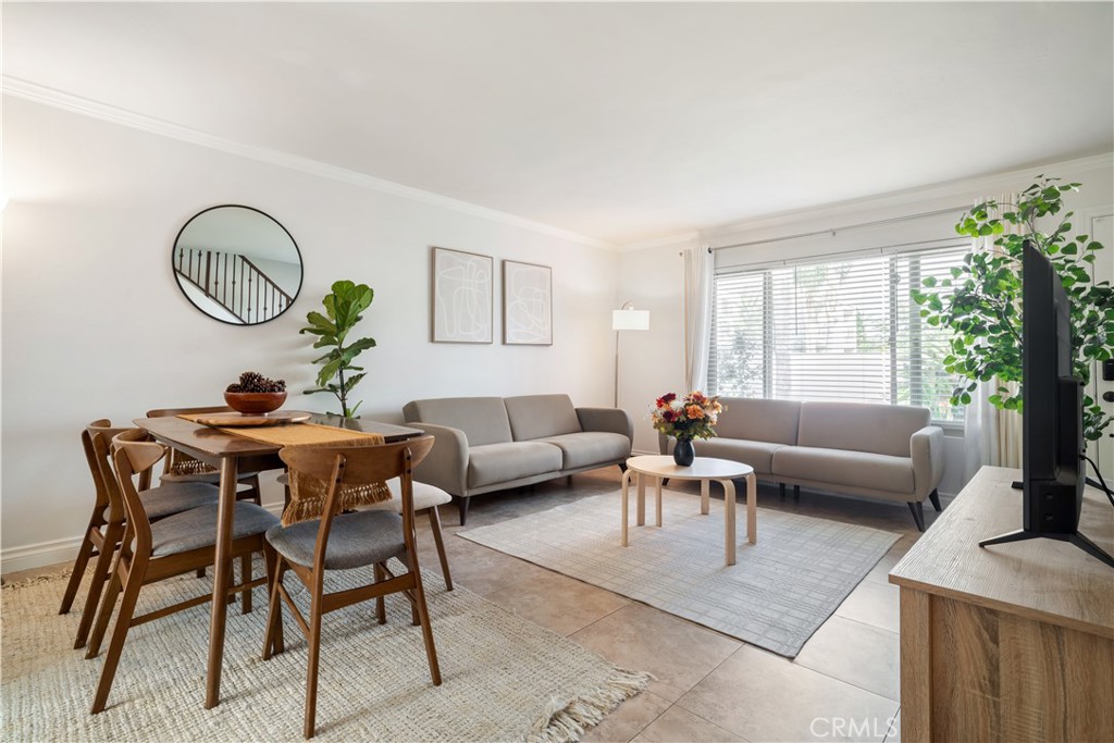 a living room with furniture a dining table and a potted plant