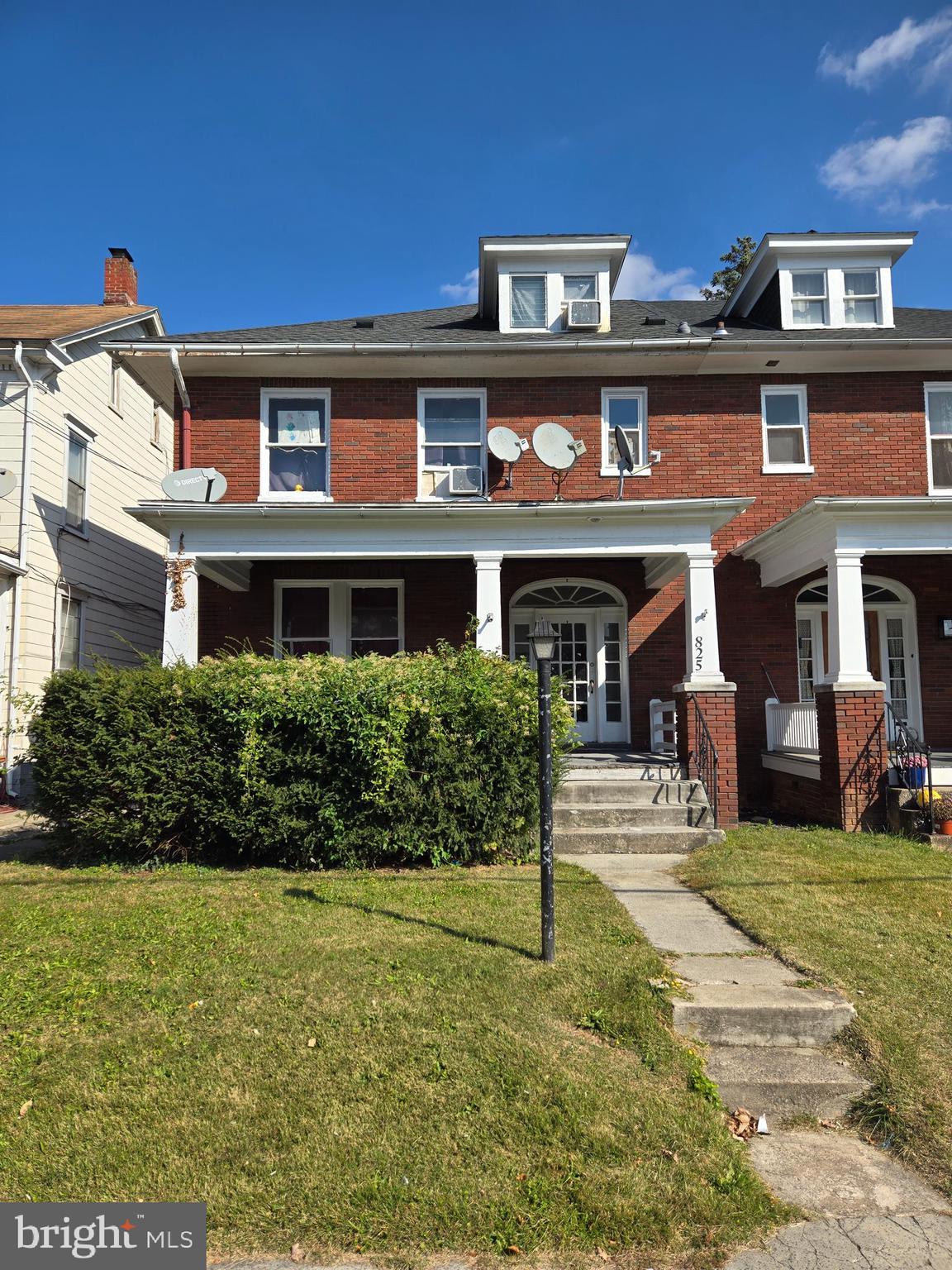 a front view of a residential apartment building with a yard