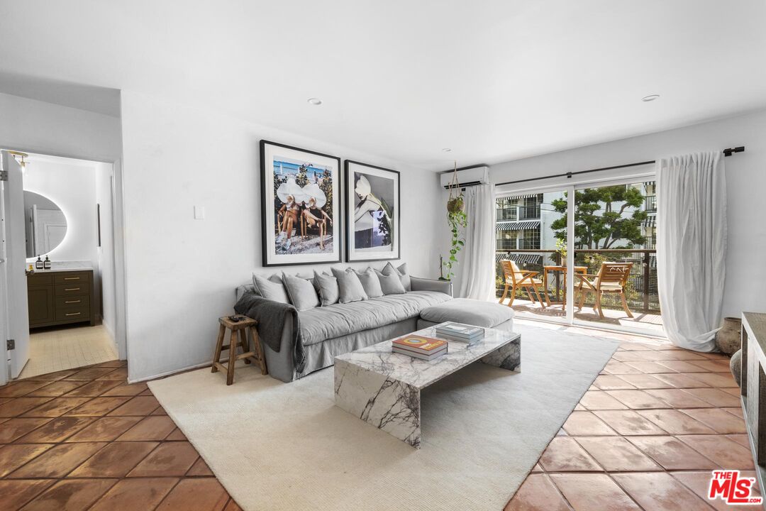 a living room with furniture and large window with garden view