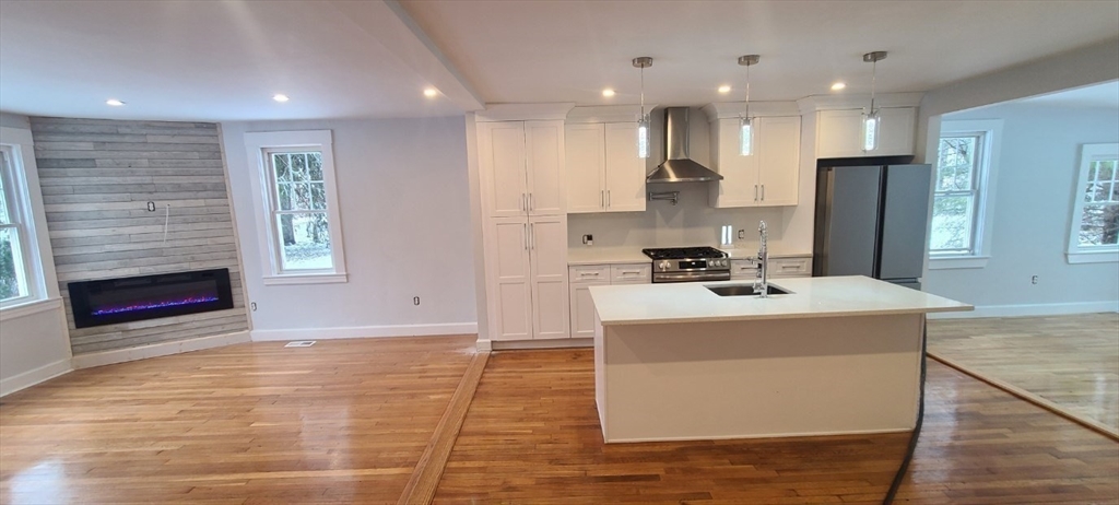 a kitchen with kitchen island white cabinets and stainless steel appliances