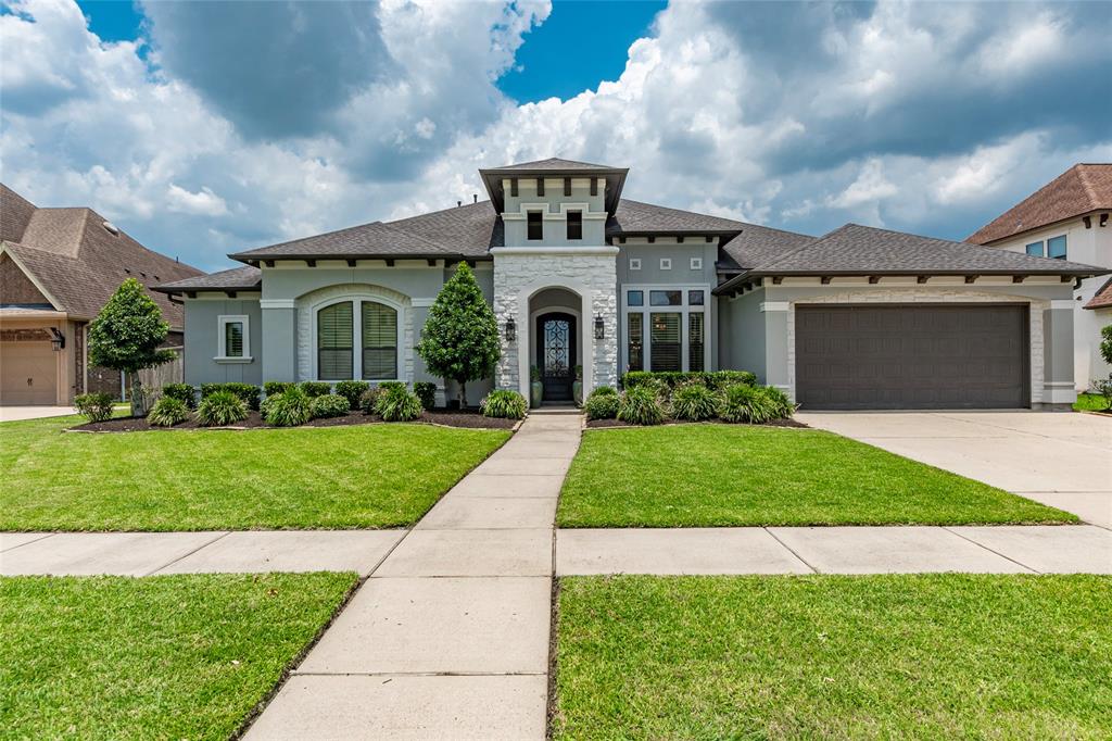 a front view of a house with a garden and yard